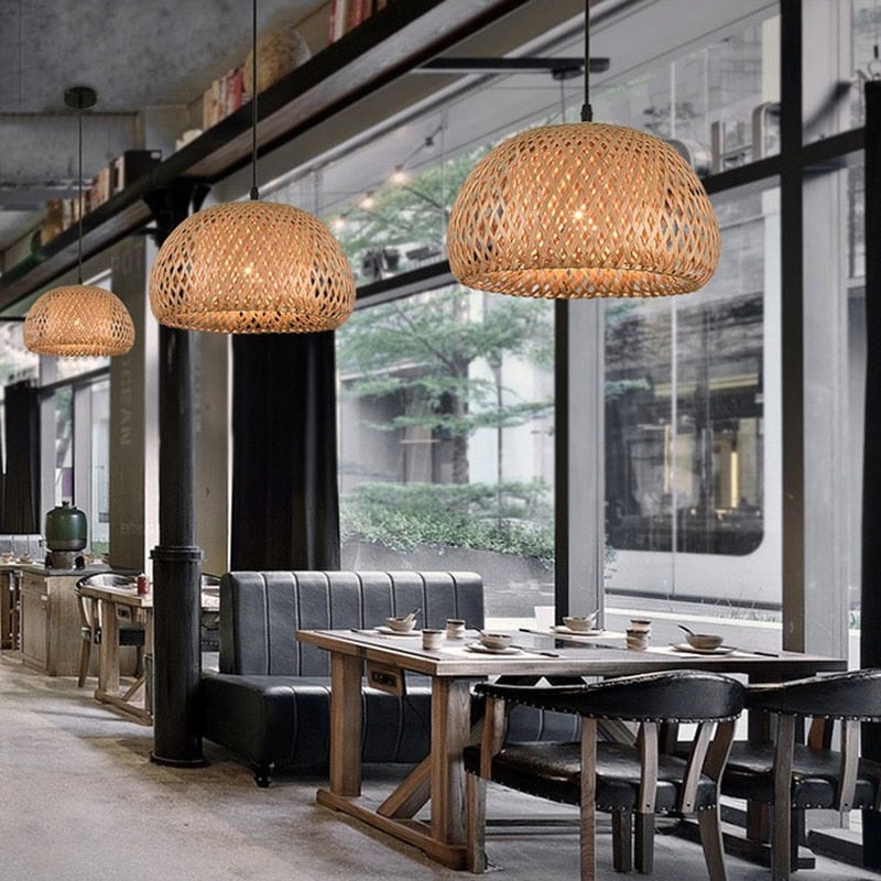 Handwoven rattan pendant lampshade hanging above a dining table in a rustic restaurant setting