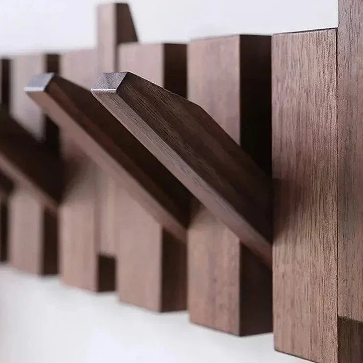 Close-up view of the angled wooden hooks on the wall rack