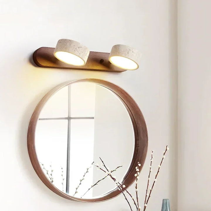 Modern LED wall lamp with stone shades mounted above a round mirror