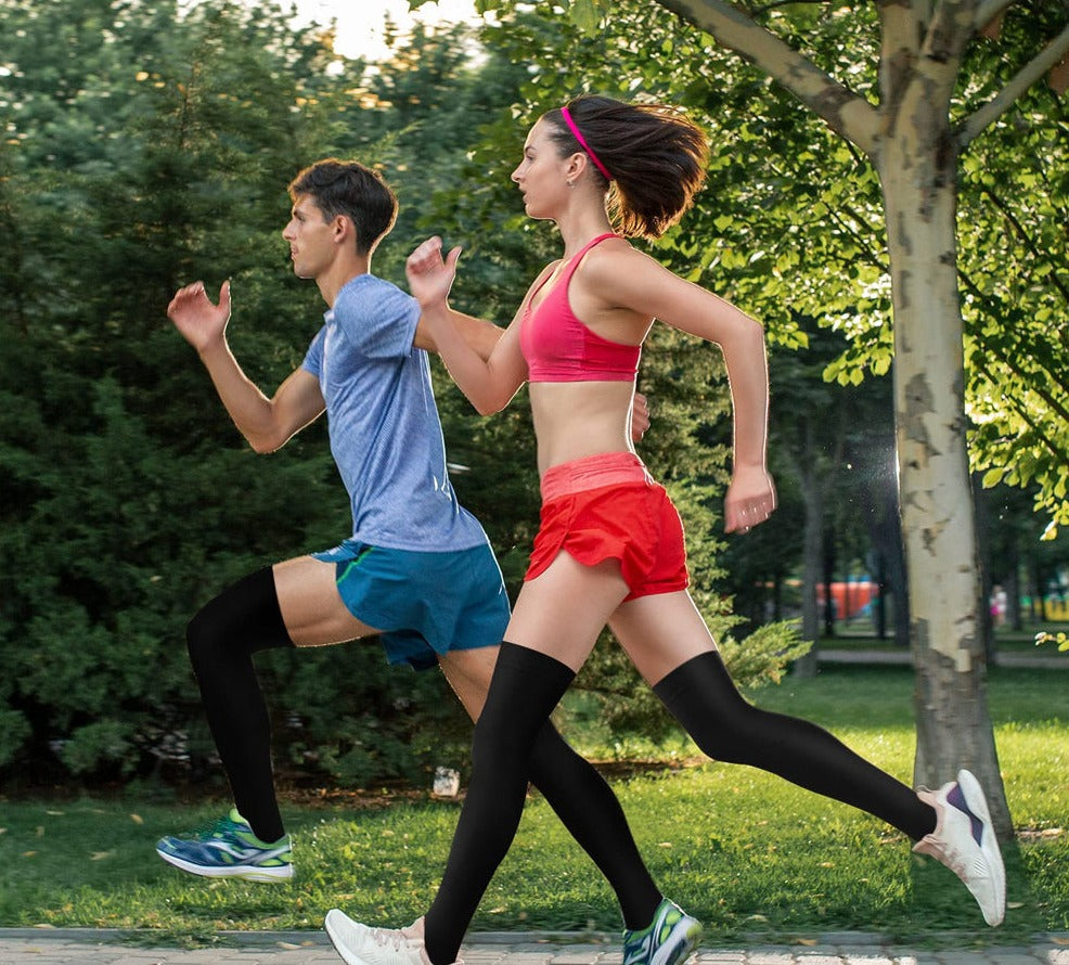 Man and woman running outdoors wearing athletic compression stockings