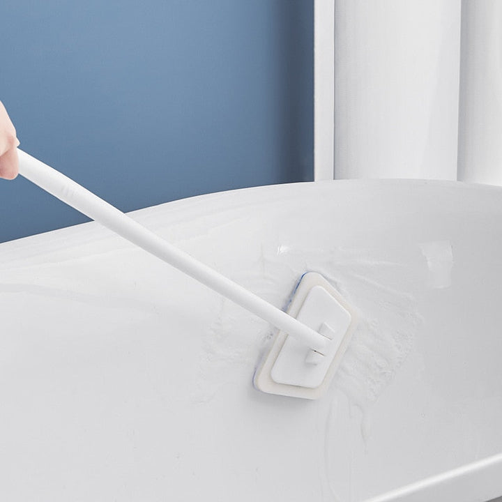 Person using CleanEase brush to clean a white bathtub surface