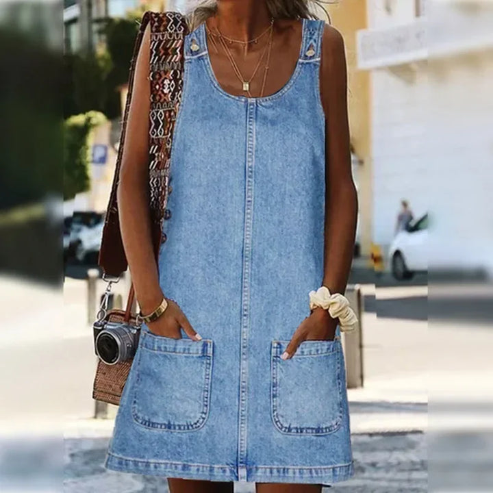 Woman wearing a light blue summer denim dress with pockets outdoors