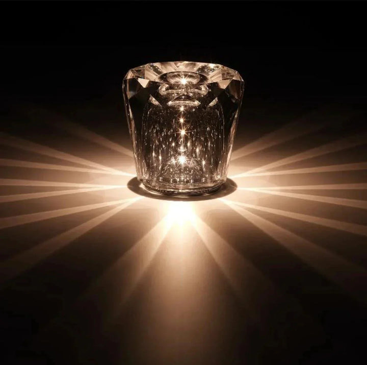 Faceted crystal table lamp glowing in a dark room