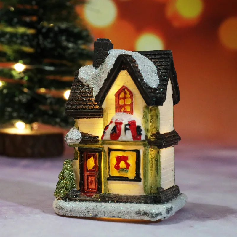 Illuminated miniature Christmas house with snow-covered roof
