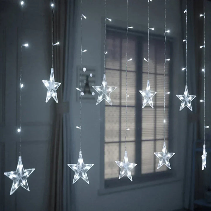 Close up of glowing star fairy lights hanging against a window