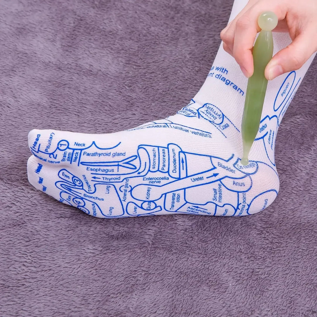 Close-up of reflexology sock pressure point chart with massage tool