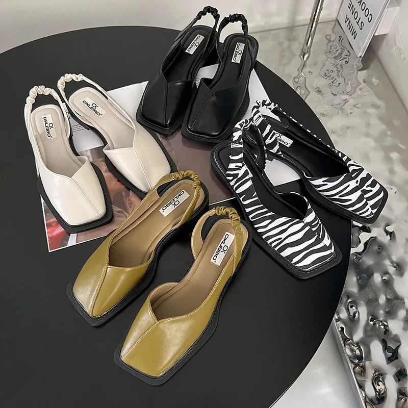 Assorted colors of women's square toe slingback sandals arranged on a modern dark table