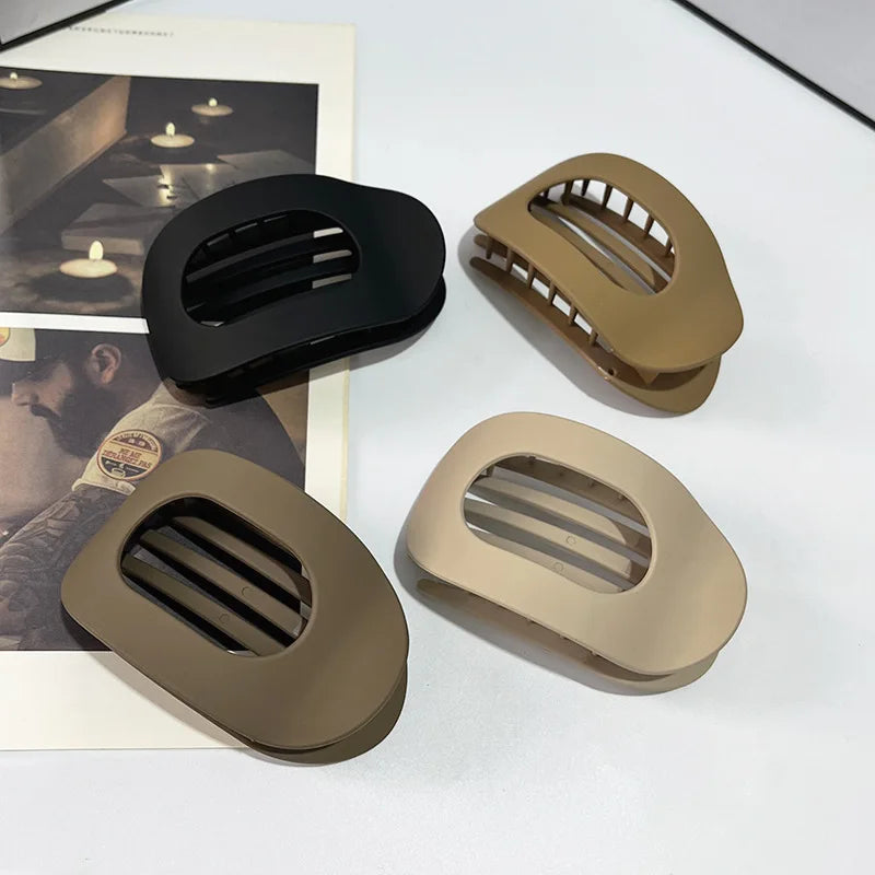Collection of four matte neutral hair claw clips in black, coffee, brown, and beige