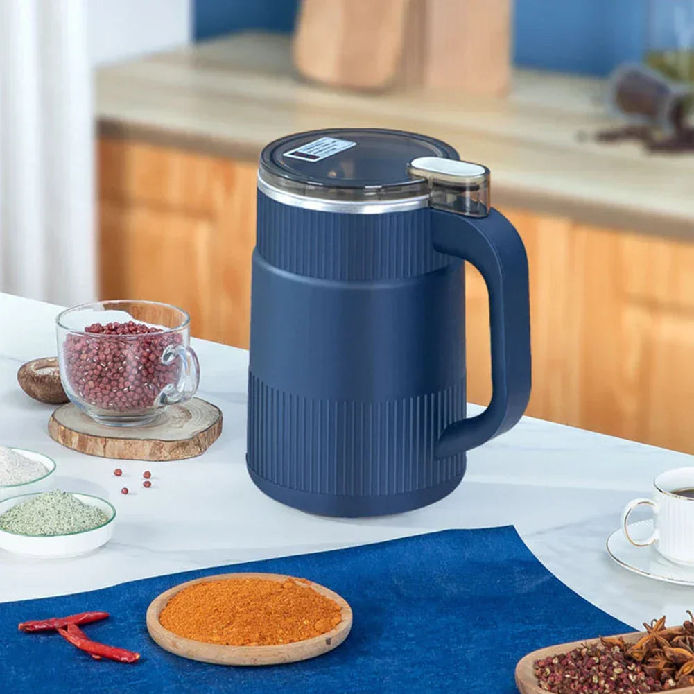 Blue compact electric spice grinder on a kitchen table with spices