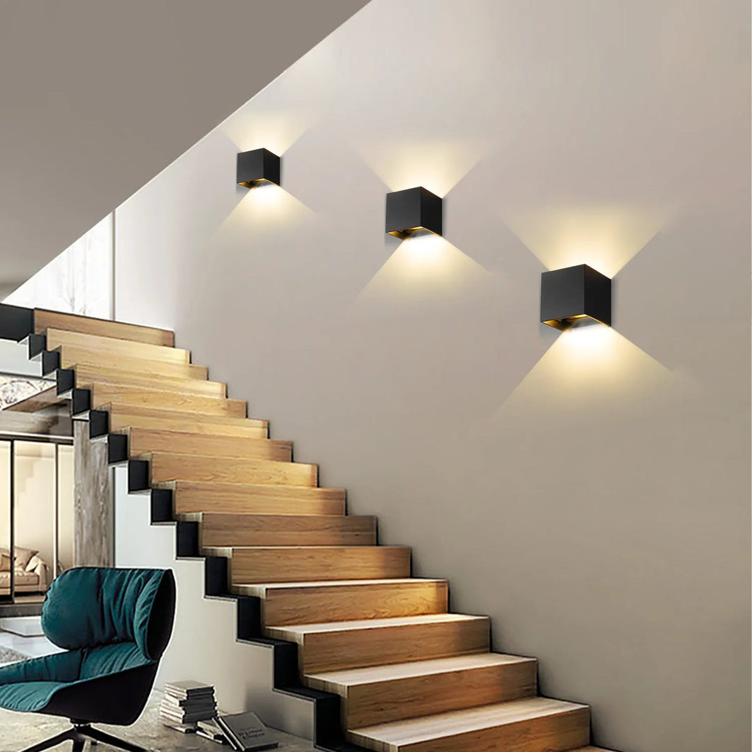 Modern black square cordless wall lamps illuminating a staircase wall
