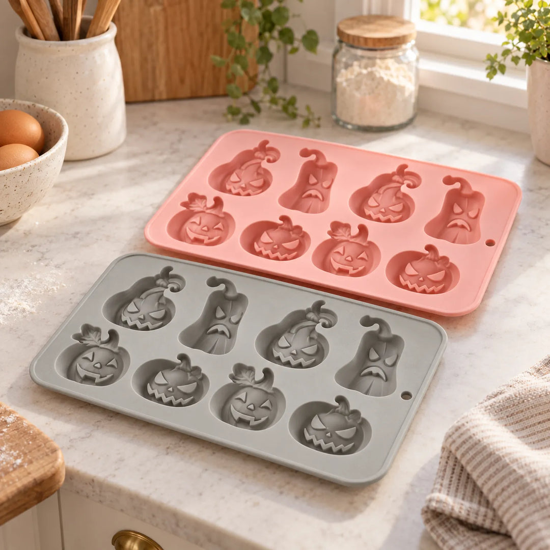 Pink and grey silicone Halloween pumpkin baking moulds on a kitchen counter
