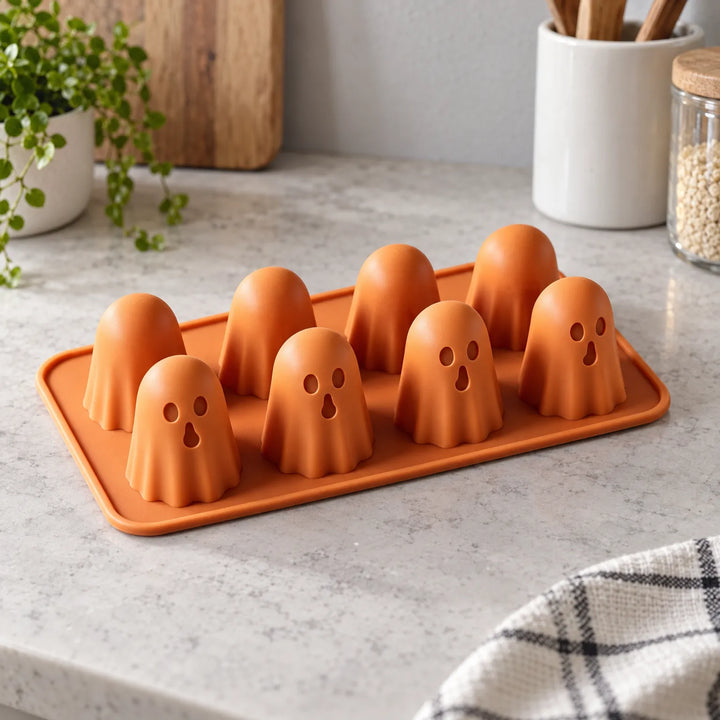 Silicone ghost chocolate mould resting on a kitchen counter next to small plants