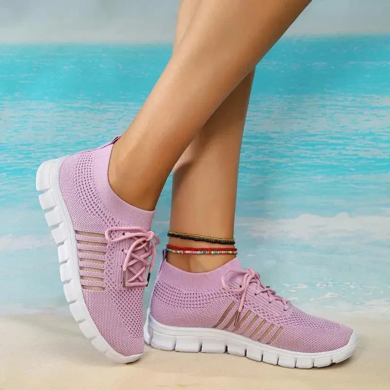 Light purple women's comfort sneakers displayed near a scenic blue background