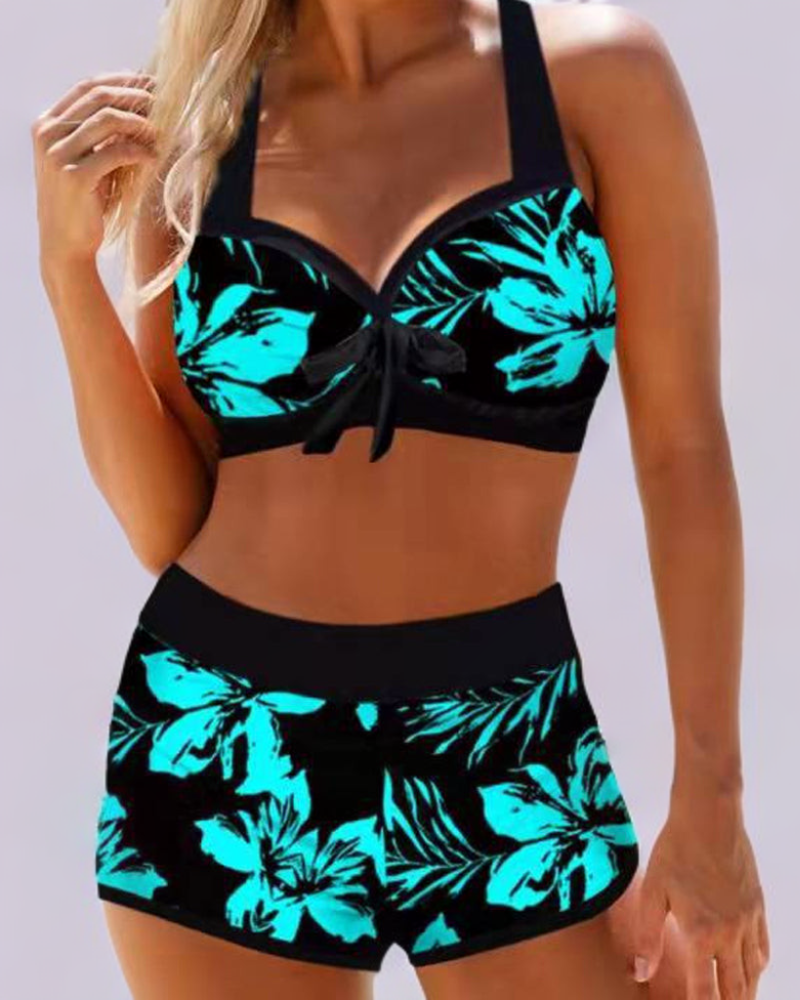 Front view of a woman wearing a black and turquoise floral high-waist swimsuit