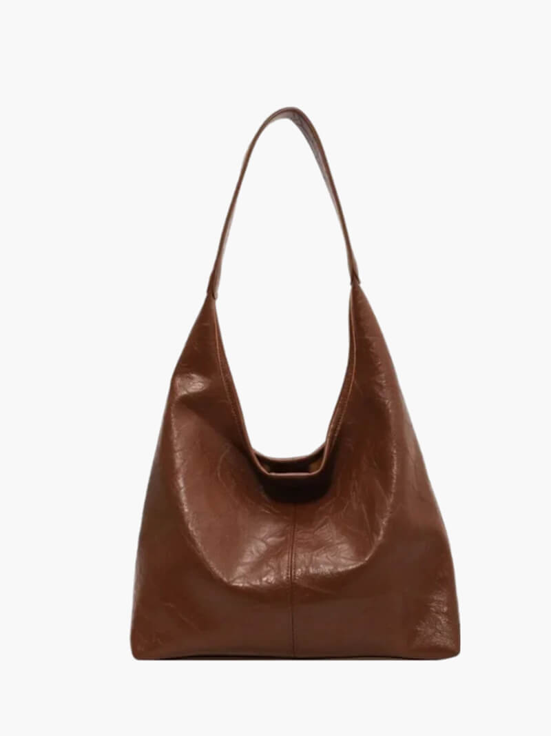 Black minimalist shoulder bag worn by a model, showing everyday handbag style