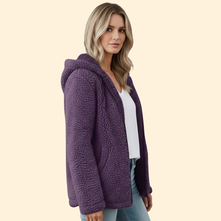 Side profile view of a blonde woman wearing a purple hooded teddy coat