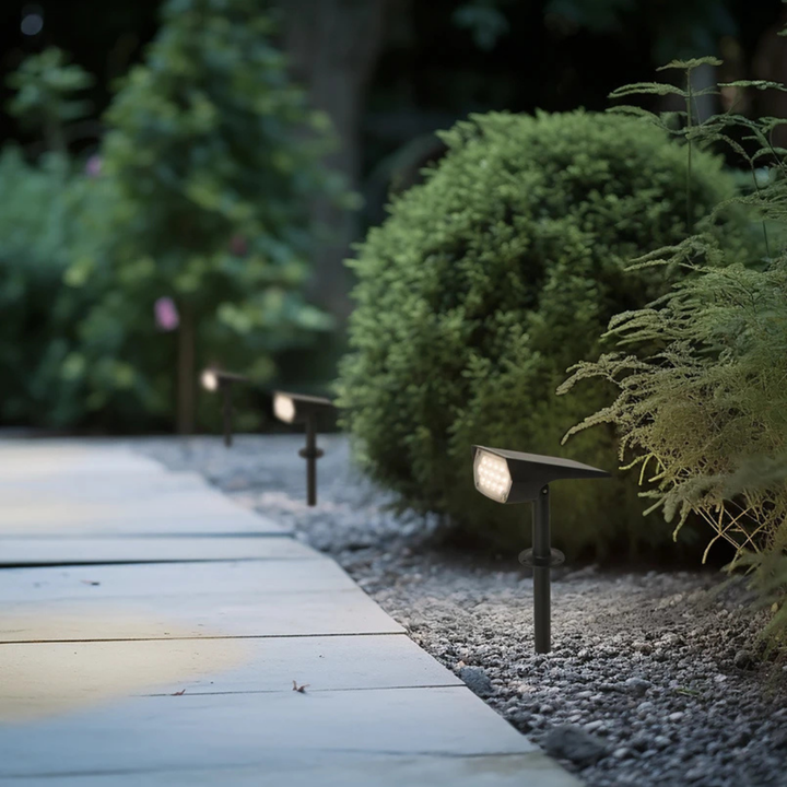 Multiple SolaraLight spotlights lining a modern garden walkway
