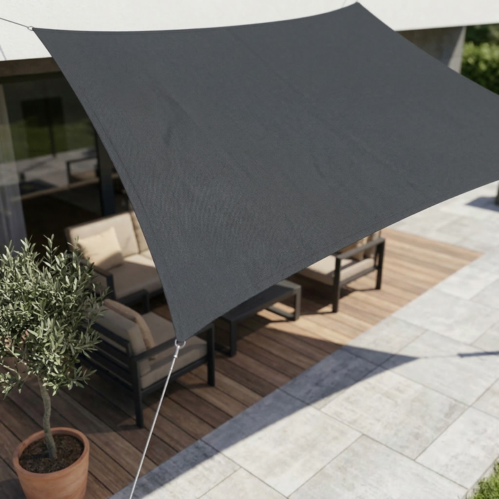 Dark grey rectangular shade sail mounted over a modern patio with outdoor seating