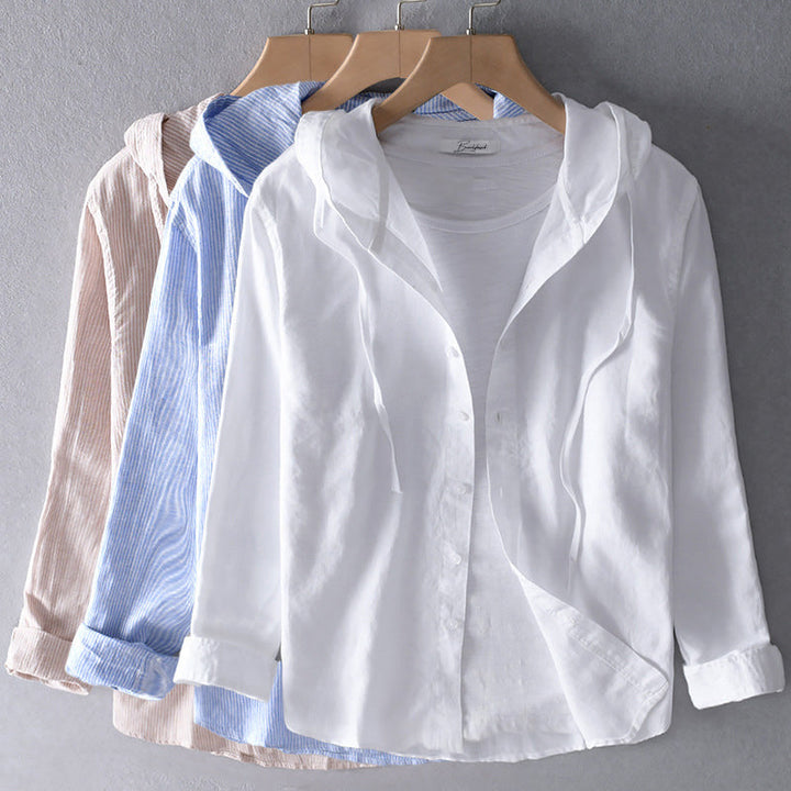 Collection of white, blue, and beige hooded blouses on hangers