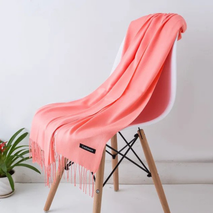 Soft winter scarf neatly rolled and displayed on a rustic surface