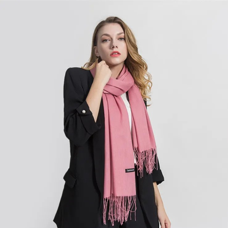 Woman wearing pink winter scarf and black blazer