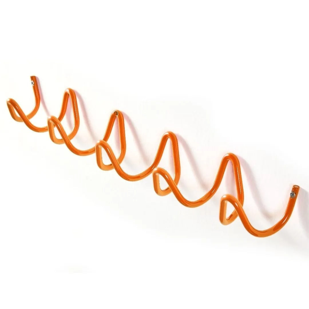 Wrought iron wall coat rack wave pattern staged with rustic decor items