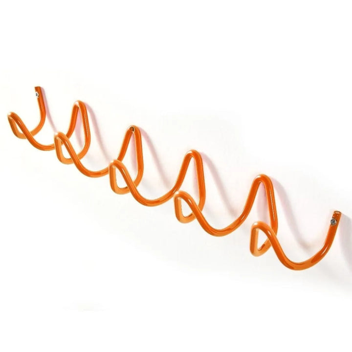 Wrought iron wall coat rack wave pattern staged with rustic decor items