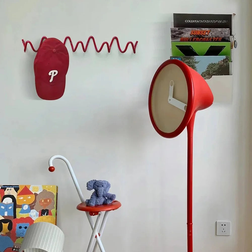 Red wave design wall coat rack holding a red cap in a modern room