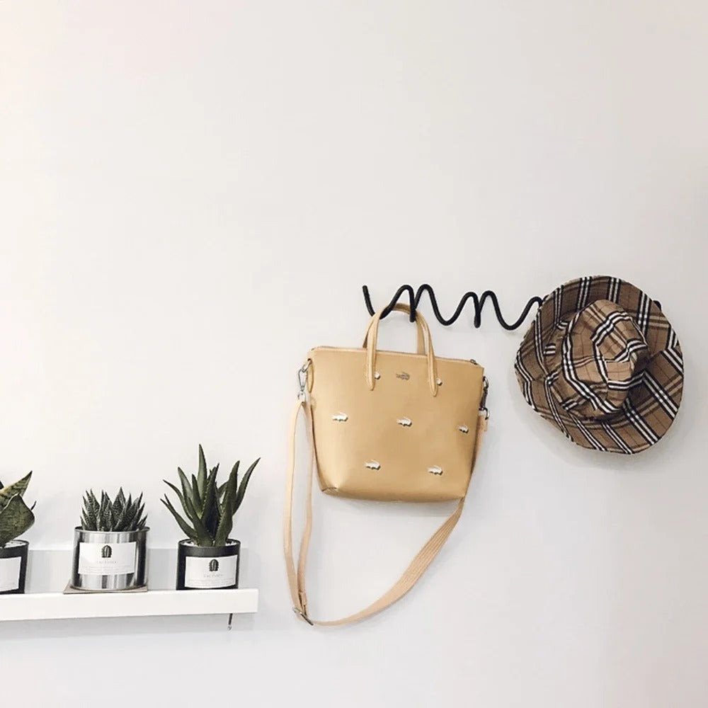 Bathroom hardware wave coat rack hanging on a neutral wall