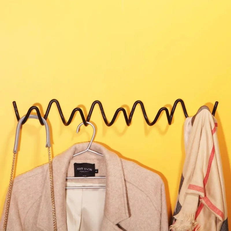 Hallway storage wrought iron wall coat rack loaded with winter jackets