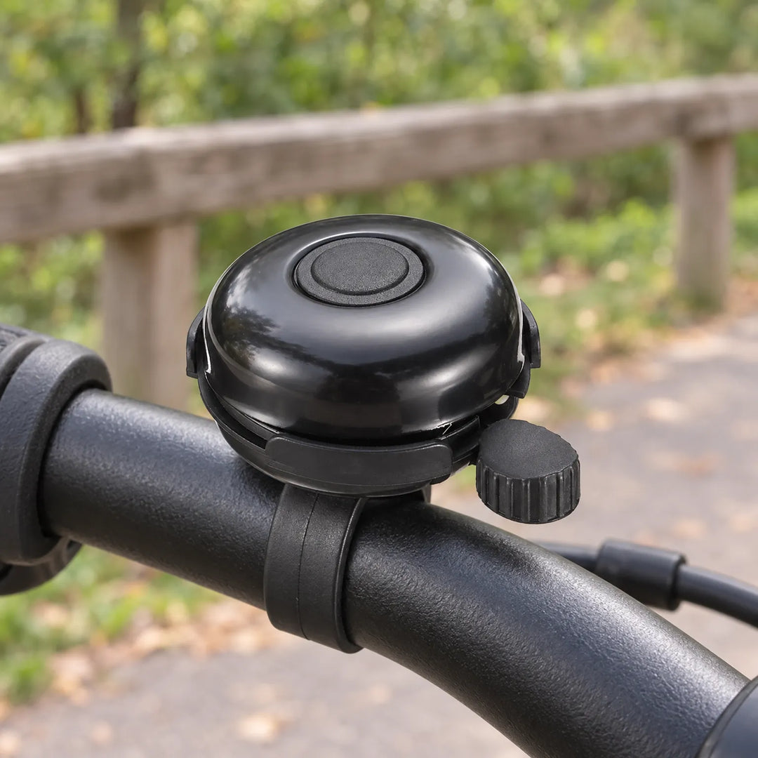 Black metal bicycle bell mounted securely on handlebar
