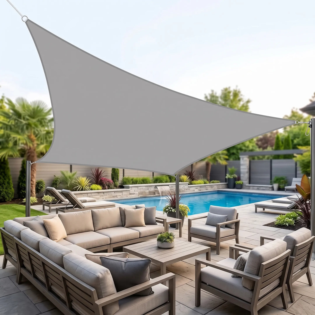 Grey rectangular shade sail installed over a luxury outdoor patio and pool area