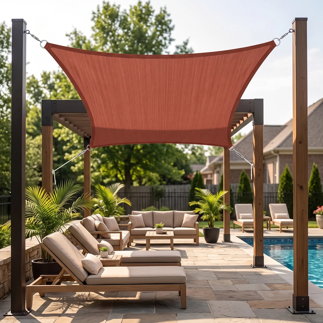 Red rectangular shade sail canopy mounted over a wooden pergola in a backyard