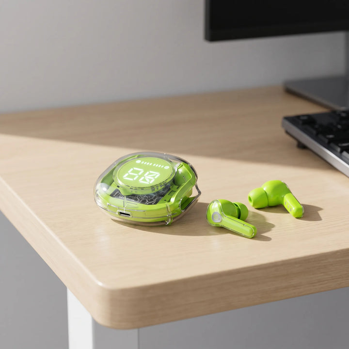Green transparent true wireless earbuds with digital charging case on a wooden desk next to a keyboard