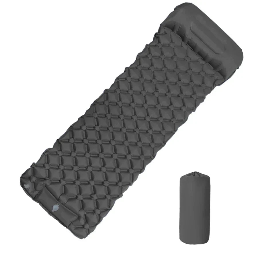 Portable sleeping pad inflated outdoors on grass, showing ergonomic design for hiking trips