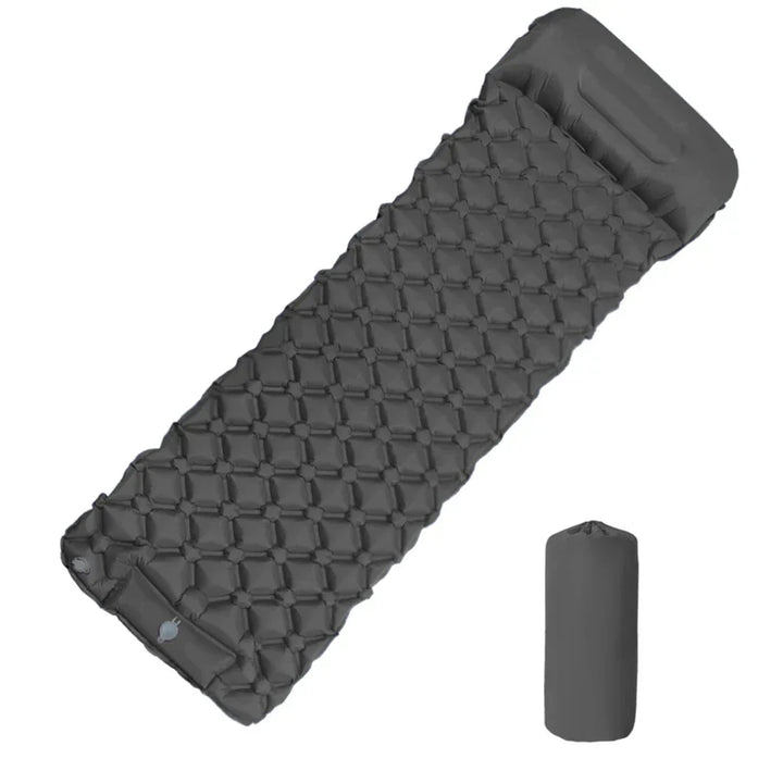Portable sleeping pad inflated outdoors on grass, showing ergonomic design for hiking trips