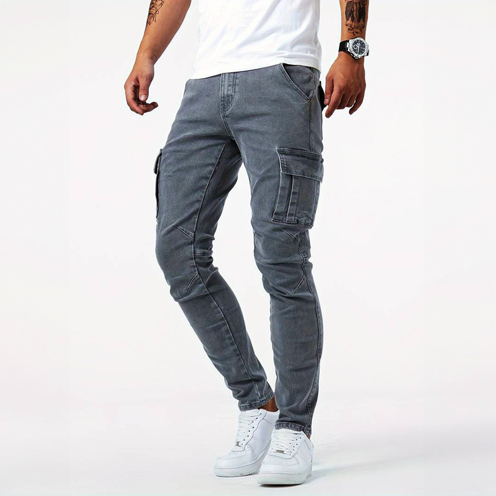 Man wearing grey slim fit cargo denim pants from the front side view