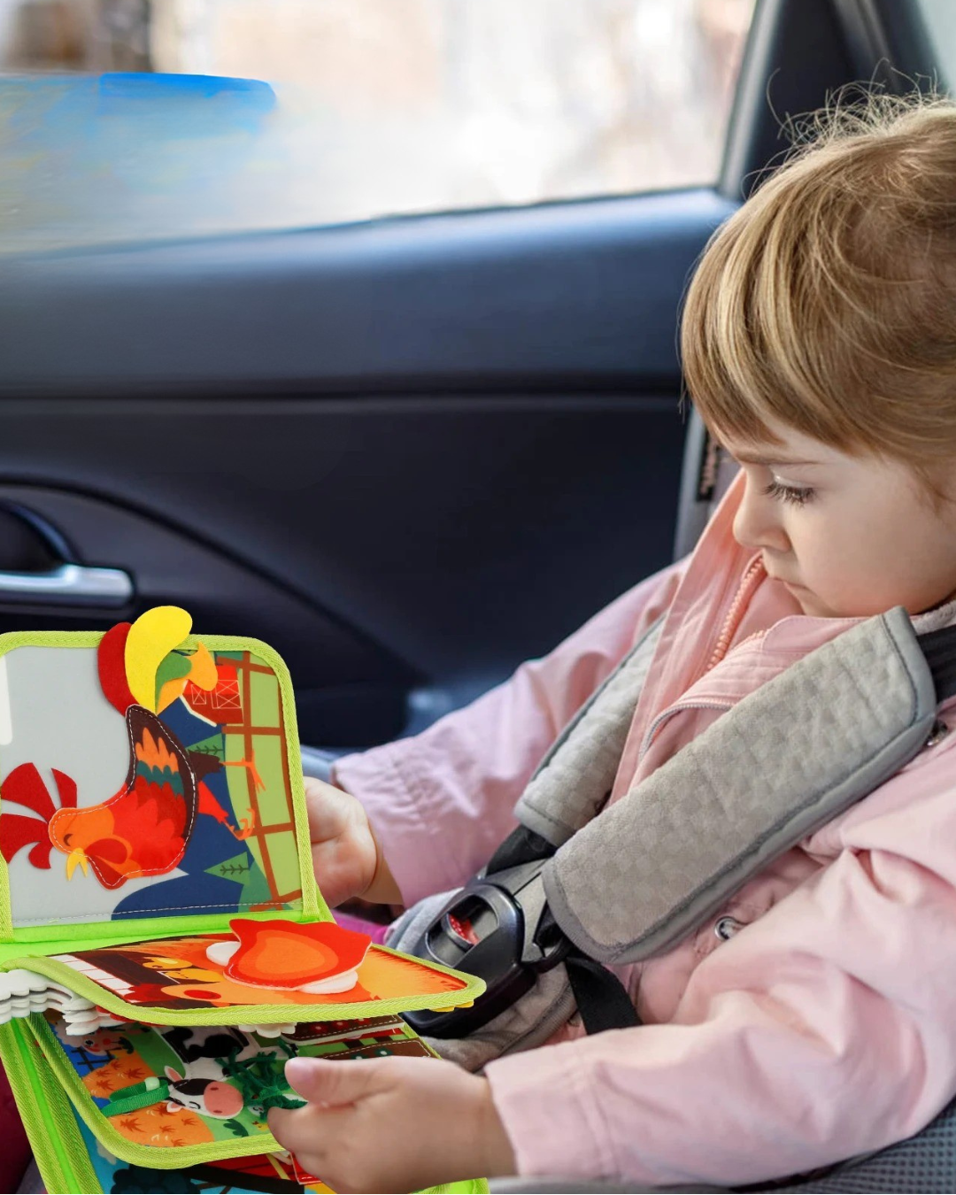 Young child holding the interactive educational farm story book in a car