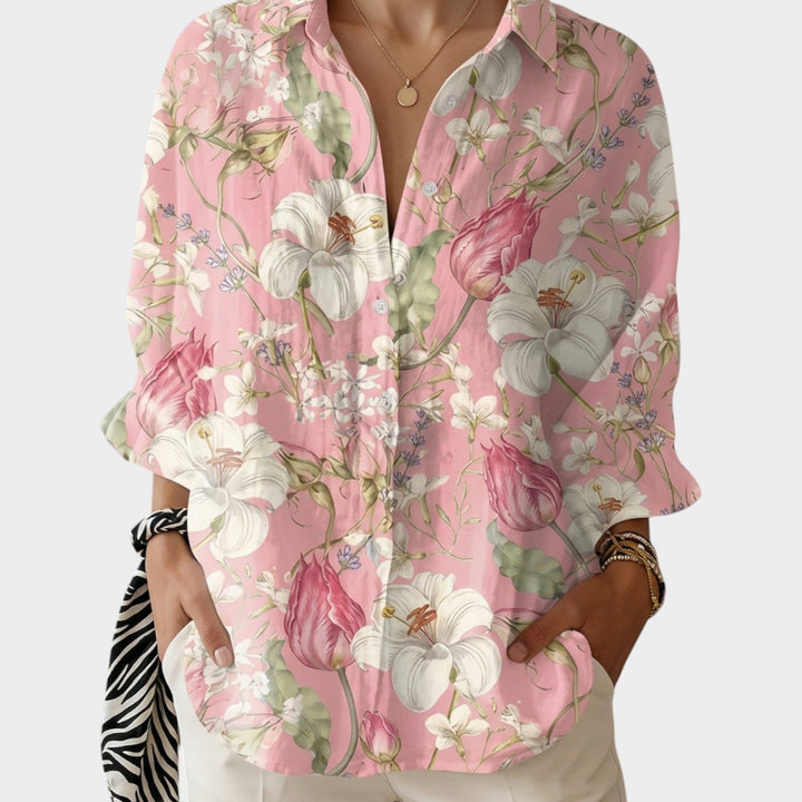 Woman wearing a pink and white floral botanical print button-up shirt.