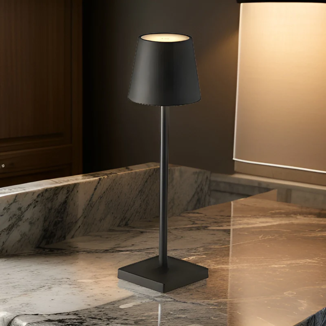 Sleek black wireless rechargeable table lamp glowing softly on a marble countertop