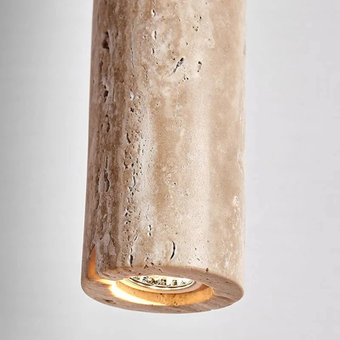 Close-up view of the textured travertine stone cylinder housing the warm LED light