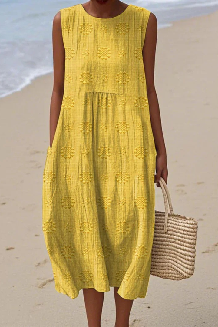 Lifestyle shot of woman wearing sleeveless embroidered pocket midi dress