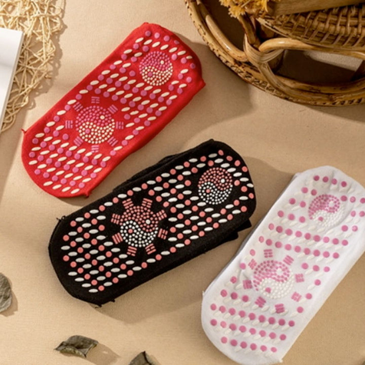 Red, black, and white self-heating socks displayed on a neutral surface