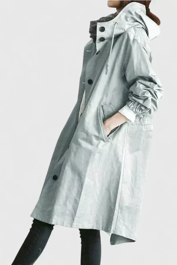 Side view of woman in light grey raincoat with adjustable hood