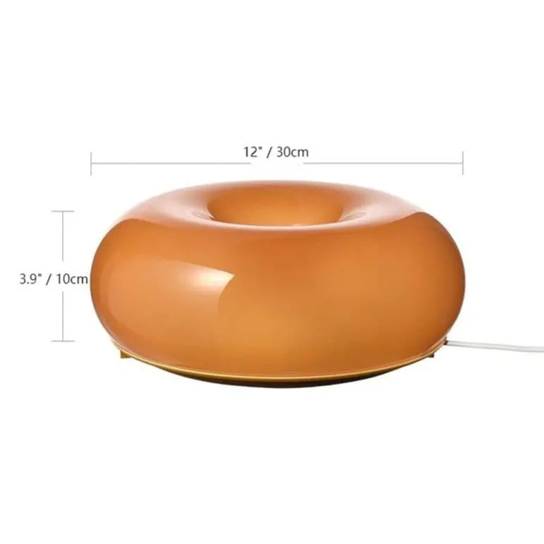 Orange donut lamp styled on a bookshelf with modern decor