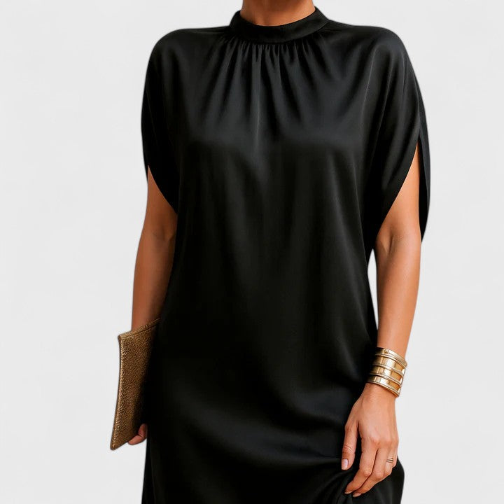 Close-up of the gathered mock neckline and flowing batwing sleeve on a black dress