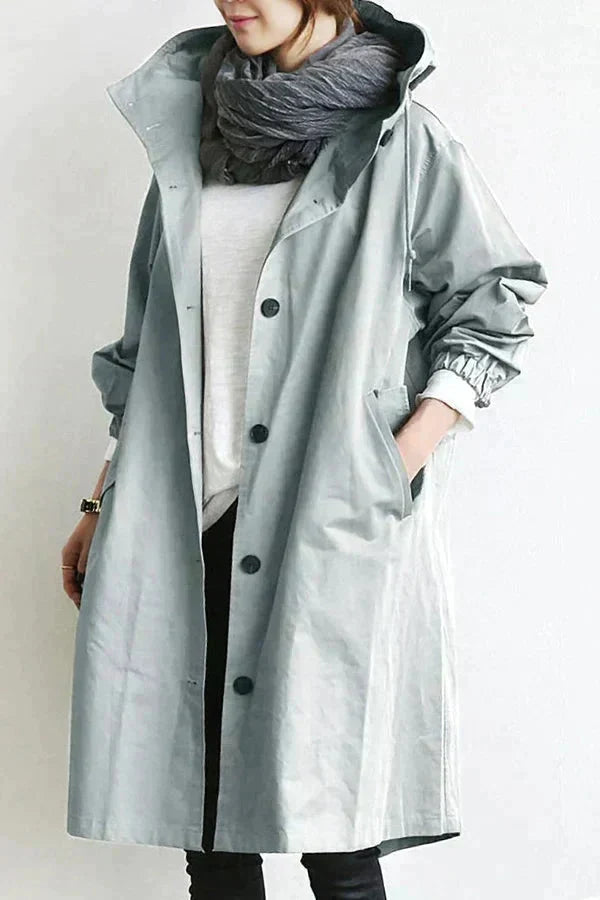 Woman wearing a grey hooded water-resistant raincoat with a large scarf
