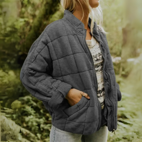Woman wearing dark gray oversized quilted puffer winter jacket with side pockets
