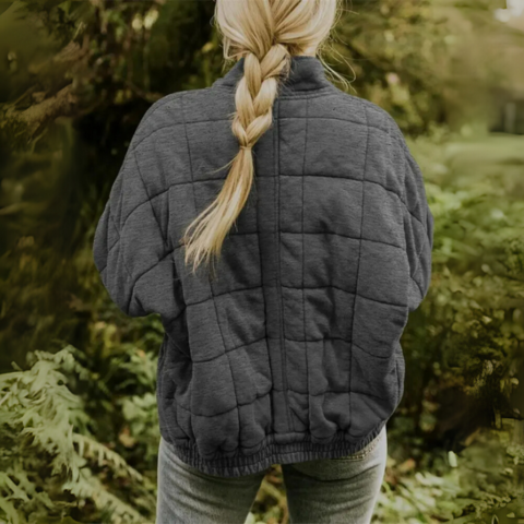 Back view of woman wearing dark gray quilted puffer jacket outdoors
