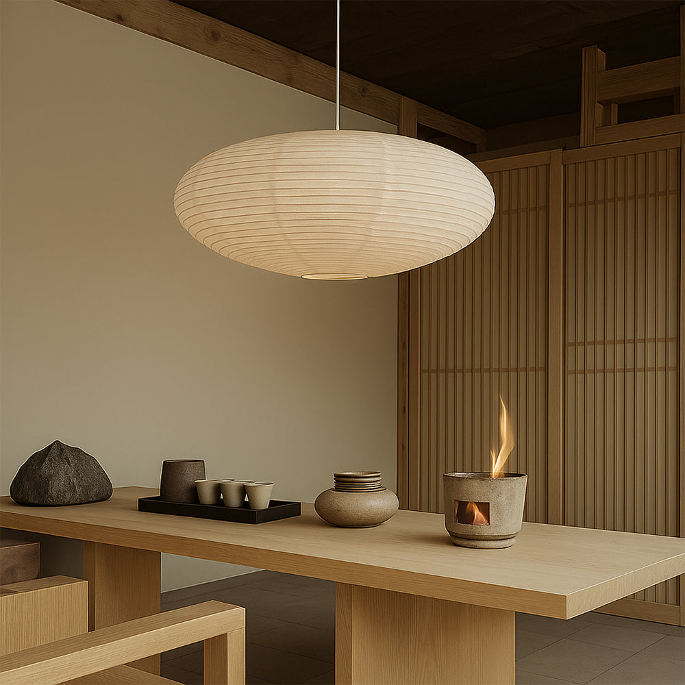 Japanese minimalist wabi-sabi pendant light hanging over a wooden dining table in a calm interior.